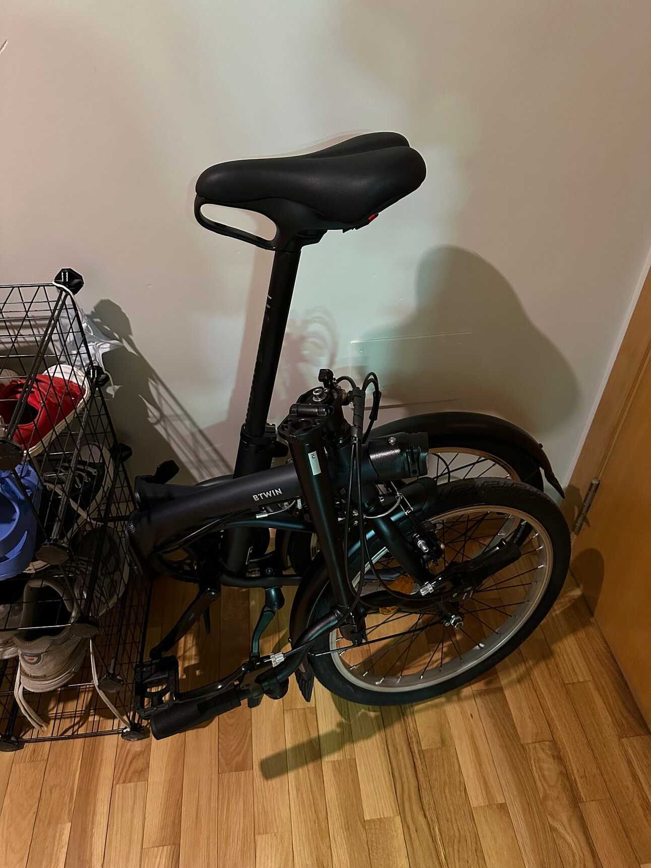 Mi bicicleta plegada, tal cual la guardo en casa, junto al zapatero de la entrada.