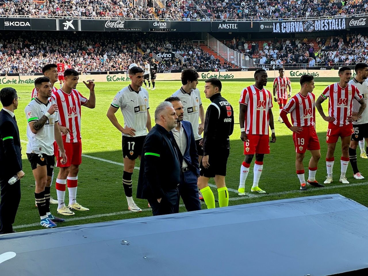 Baraja, entrenador del Valencia, con jugadores de su equipo y del Almería mirando cómo el árbitro escudriña la pantalla del VAR.